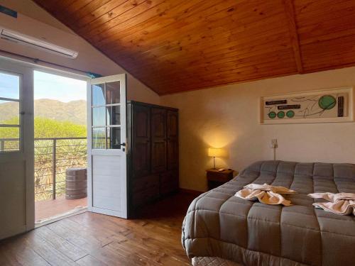 Un dormitorio con una cama y una puerta corrediza de vidrio. en Cabañas Caranday, en Capilla del Monte