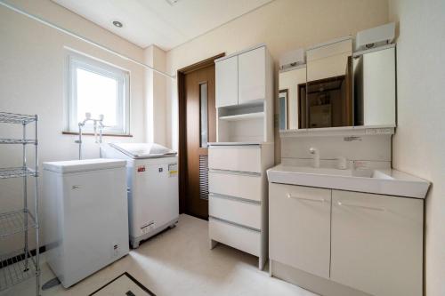 a white kitchen with a sink and a microwave at SEKKA - Vacation STAY 20179 in Shimo-furano