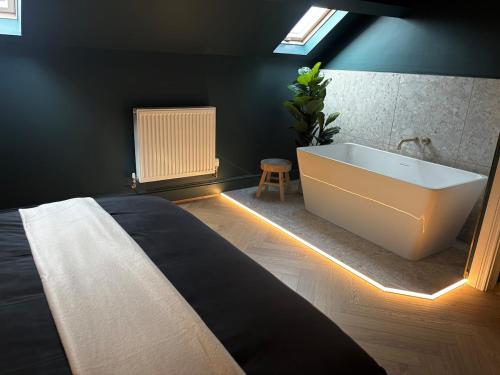 a bedroom with a bed and a bath tub at NEW Luxury Neath Center Stay in Neath