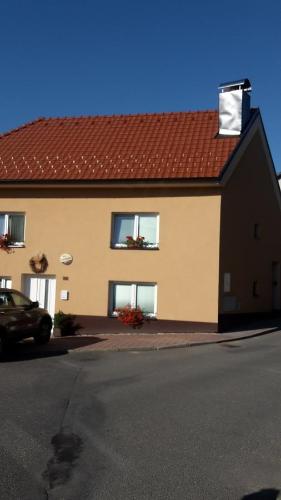 una casa con techo rojo y un coche aparcado delante en Apartment Pod Kotnovem, en Tábor