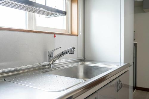 ein Waschbecken in einer Küche mit Fenster in der Unterkunft Asahikawa - House - Vacation STAY 20194 in Shin-asahigawa