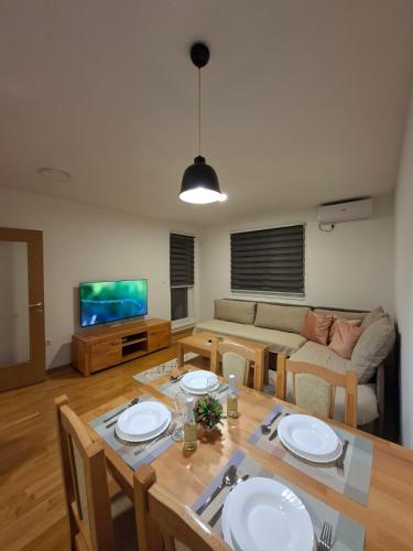 a living room with a table and a couch at Stan na dan Ramonda in Donje Mladice