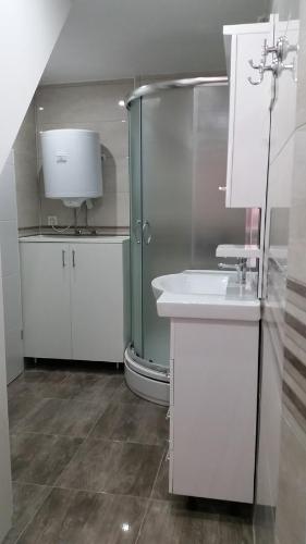 a white bathroom with a shower and a sink at Apartment Soric in Senj