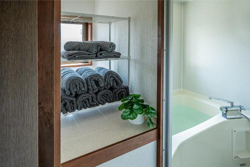 a bathroom with a towel rack and a bath tub at Aso Play - Harmony and Unity - Vacation STAY 42457v in Uchinomaki
