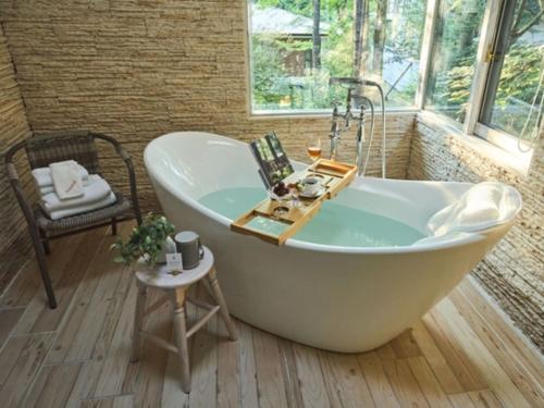a white bath tub in a room with windows at Auberge de Primavera - Vacation STAY 40807v in Shin-karuisawa