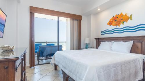 a bedroom with a bed and a view of the ocean at Las Palomas 2 BR 2 BA Diamante 707 in Puerto Peñasco