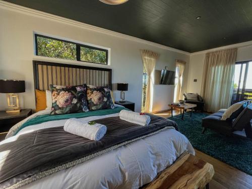 a bedroom with a large bed with two pillows at Treetop Guesthouse in Gqeberha