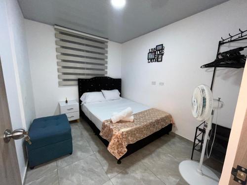 a small bedroom with a bed and a fan at Apartamento Vacacional Familiar en Girardot, piscinas, Jacuzis, parqueadero privado in Girardot