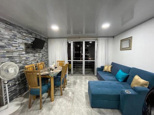a living room with a blue couch and a table at Apartamento Vacacional Familiar en Girardot, piscinas, Jacuzis, parqueadero privado in Girardot