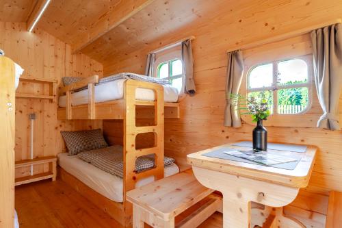 a log cabin with bunk beds and a desk at LummersDorf in Sankt Johann am Wimberg