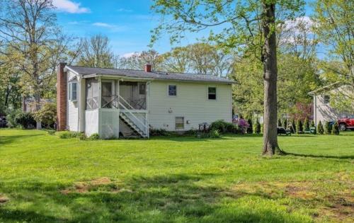 a white house with a tree in the yard at Summit & Shore House, Whole House in Colchester