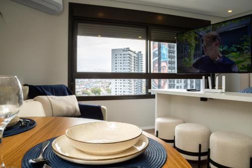 une salle à manger avec une table et une télévision dans l'établissement Loft 907 Parque Una - Aurora, à Pelotas