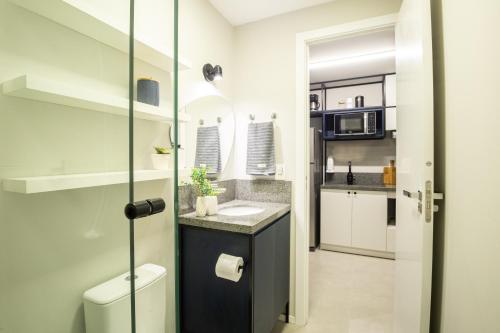 une petite cuisine avec un évier et un micro-ondes dans l'établissement Loft 907 Parque Una - Aurora, à Pelotas