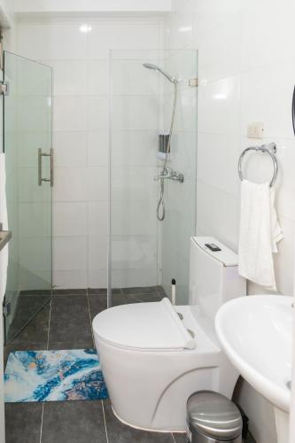 a bathroom with a toilet and a glass shower at La Isla Royal - Pool Side Suite in Miches