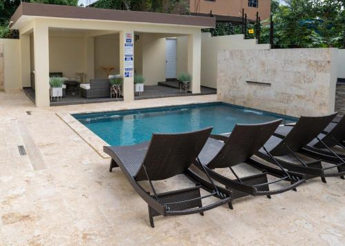 a group of chairs sitting next to a swimming pool at La Isla Royal - Pool Side Suite in Miches