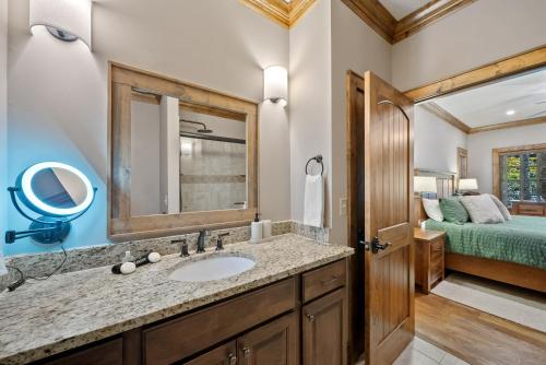un bagno con lavandino, specchio e letto di Our Evergreen Retreat a Boone Fork