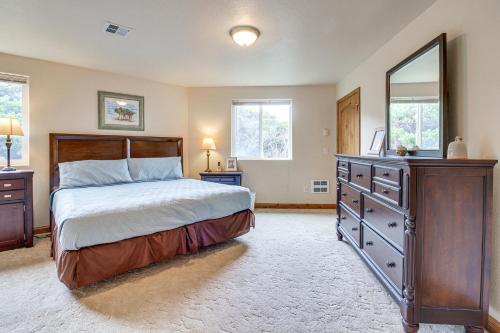 a bedroom with a bed and a dresser and a mirror at Groups Welcome! Ocean-View Escape in Gold Beach in Gold Beach
