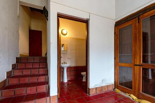 a bathroom with a toilet and a sink and stairs at La Ramada in Tafí del Valle