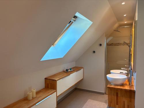 a bathroom with a sink and a skylight at Charmante maison avec piscine in Turquant