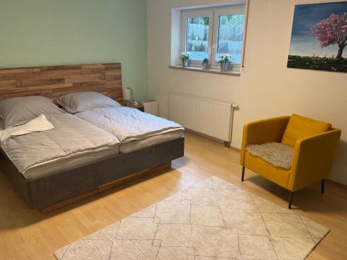 OberteuringenBusiness & Monteur Apartment - Modern Style & Comfort - Bodensee-Oberschwaben的一间卧室，里面有一张床、一把椅子和一扇窗户