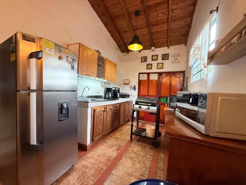 a kitchen with a stainless steel refrigerator and wooden cabinets at Casa incluyendo Glamping! 13 personas, Familias con niños in Jardin