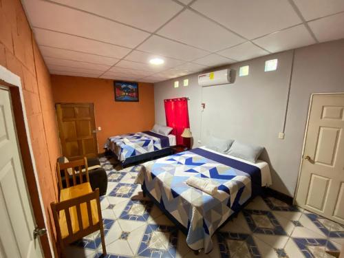 a room with two beds and a table and chairs at Casa Cahuí in El Remate
