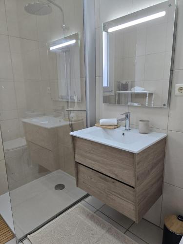 a bathroom with a sink and a mirror and a shower at Casa da Cruz in Machico