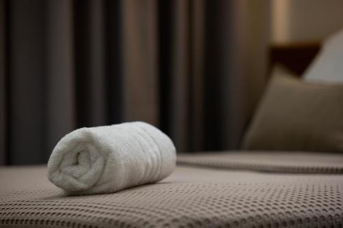 a white towel sitting on top of a bed at Aristotelous rooms Nikol in Thessaloniki