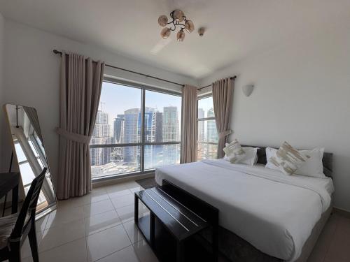 a bedroom with a large bed and a large window at 2 Bed Apartment in La Riviera Tower, Dubai Marina near Metro and Mall, 12-min walk to JBR Beach! in Dubai