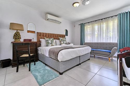 Un dormitorio con una cama, un escritorio y una silla. en Aviator's Nest, en Kempton Park