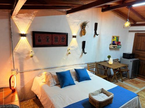 a bedroom with a bed with blue pillows and a table at Casa & cabaña campestre equipadas, 13 personas, familias in Jardin