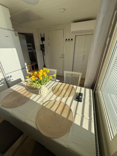 a table with a vase of yellow flowers on it at Jönåker Cottage & Sauna in Jönåker