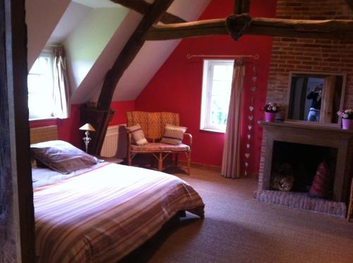 a bedroom with a bed and a fireplace at Chambre d'Hôte Près de Deauville in Surville