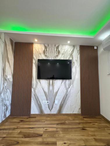 Zimmer mit einem TV an der Wand in der Unterkunft Apartmani AX in Pančevo