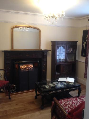 a living room with a fireplace and a mirror at 5 bedroom Town House in Dungarvan