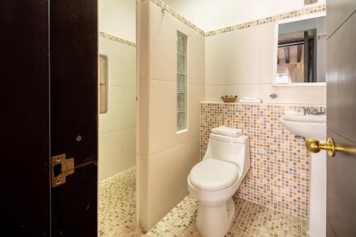 un baño con inodoro y lavabo en La Iguana Vallarta LGBT ADULTS ONLY - Romantic Zone - Party Clubbing Street, en Puerto Vallarta