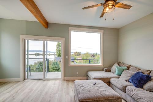 a living room with a couch and a large window at Astoria Home Base with River Views, 3 Mi to Dtwn! in Tongue Point Village