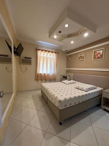 un dormitorio con una cama en una habitación en Flats Ponte Pênsil, en São Vicente