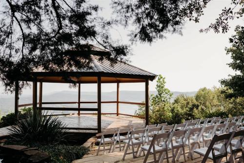 a group of white chairs and a gazebo at The Summit - 4 cabin getaway for 20 guests with views in Bryant