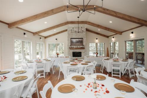 a dining room with white tables and white chairs at The Summit - 4 cabin getaway for 20 guests with views in Bryant