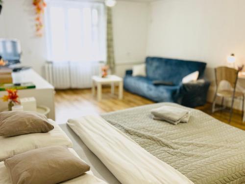 a bedroom with two beds and a blue couch at Duży apartament z kuchnią i łazienką in Namysłów