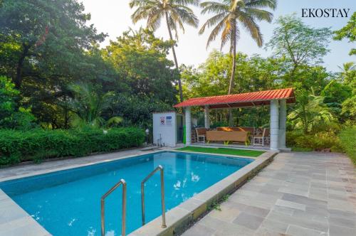 a swimming pool in a backyard with a gazebo at EKOSTAY - Fern Wood Villa 