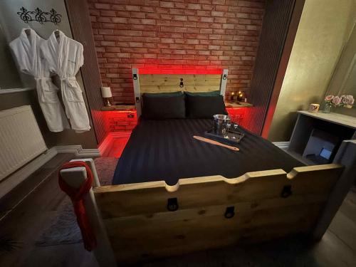 een groot bed in een kamer met een bakstenen muur bij The Alchemy in Bournemouth