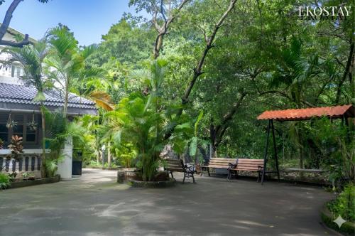 a park with a bench and a swing and trees at EKOSTAY - Fern Wood Villa 
