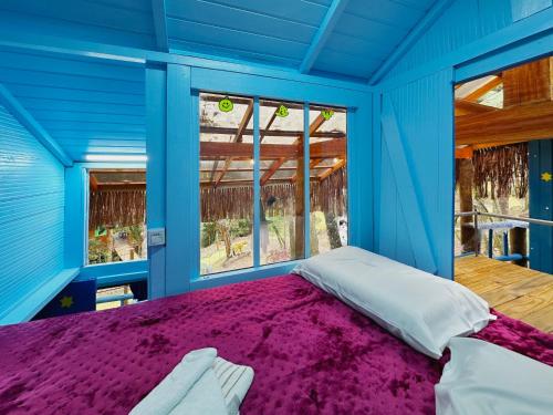 a blue room with a bed and a window at Furgão Ghost - Vila Mágica in Bueno Brandão