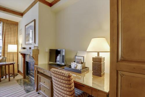 un salon avec un bureau, une télévision et une lampe dans l'établissement Studio 373 at The Lodge at Spruce Peak, à Stowe Mountain