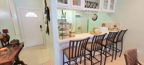 a kitchen with a bar with chairs and a counter at Great Location Pool Near the Beach in South Padre Island