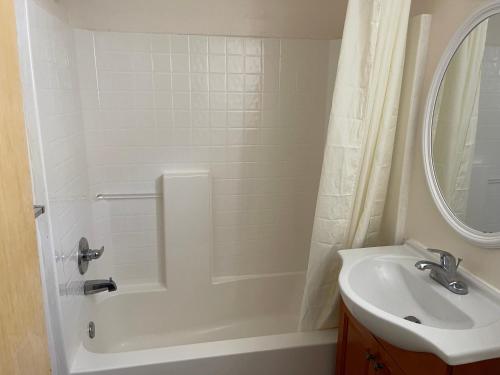 een badkamer met een bad, een wastafel en een douche bij Paramount Motel Pocono in East Stroudsburg