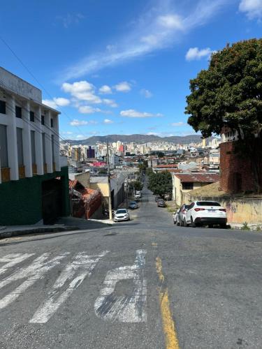 an empty street in a city with cars parked at Guest House BH in Belo Horizonte
