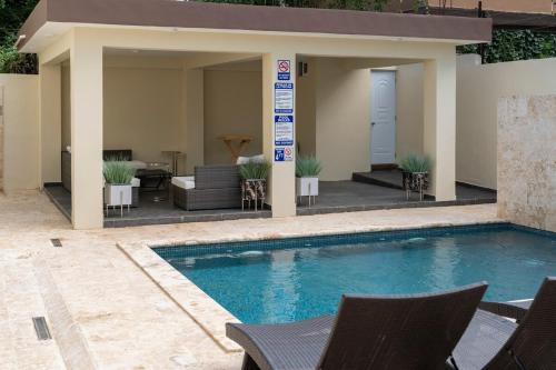 una piscina con sedie e una casa di La Isla Royal - Luminancia Eterna a Miches